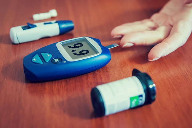 Close up of woman hands using lancet on finger to check blood sugar level