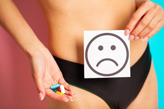 Close up of woman having female health problems holding card with sad smile