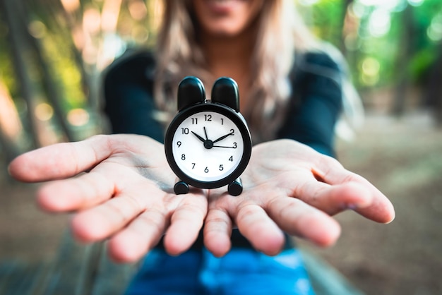 Photo close-up of woman holding clock