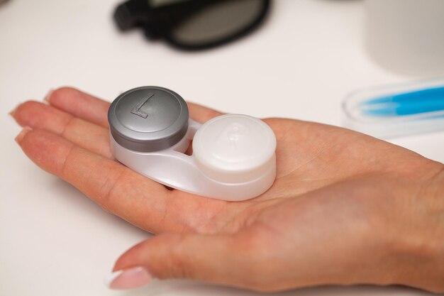 Close up of woman holding container with contact lenses