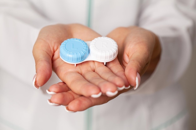 Close up of woman holding container with contact lenses