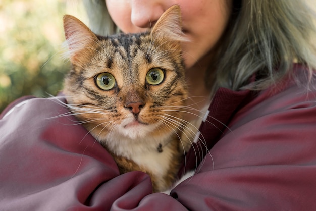 Close-up of a woman hugging her tabby cat