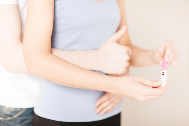 close up of woman and man hands with pregnancy test