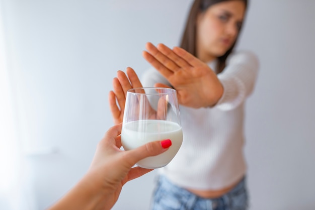 Close-up Of A Woman Rejecting Glass Of Milk At Home.