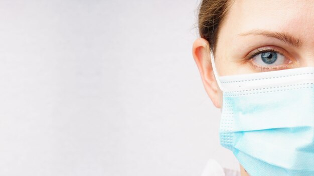 Close-up of a woman's face in a medical mask.