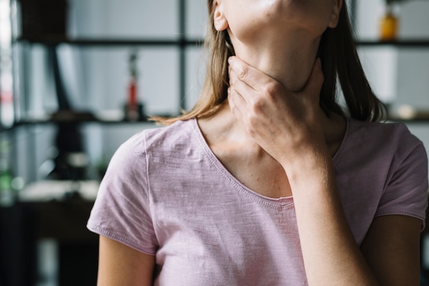 Photo close-up of a woman's hand touching her neck