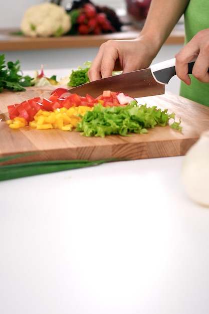 Close up of woman's hands cooking in the kitchen Housewife slicing fresh salad Vegetarian and healthily cooking concept