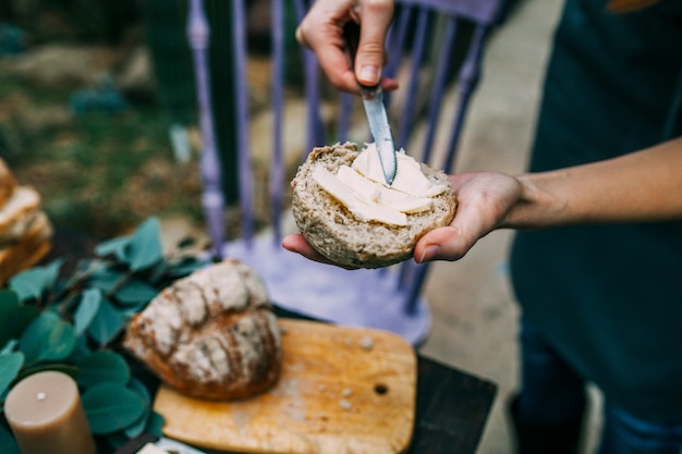 Close-up of a woman smearing butter on bread