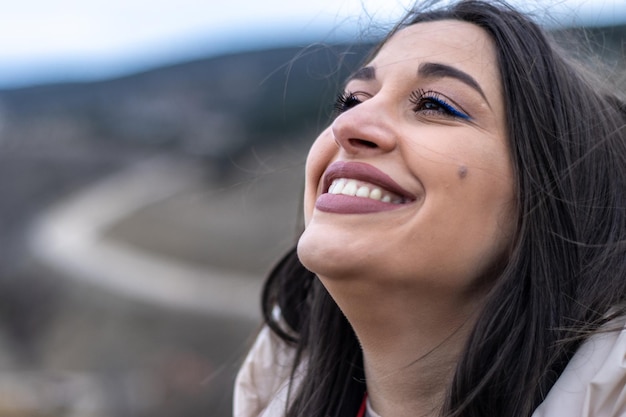 Close up of a woman smiling and looking at the sky in nature