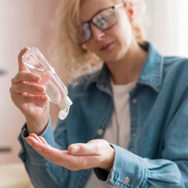 Close-up woman using hand sanitizer