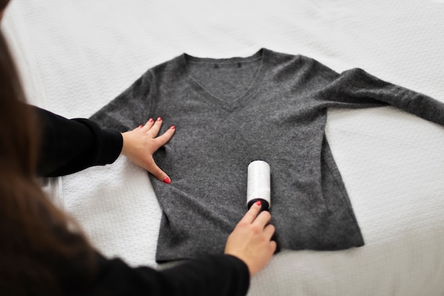 Close up woman using lint roller