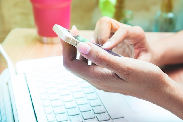 Close up woman using mobile phone and laptop. Online shopping. Using technology