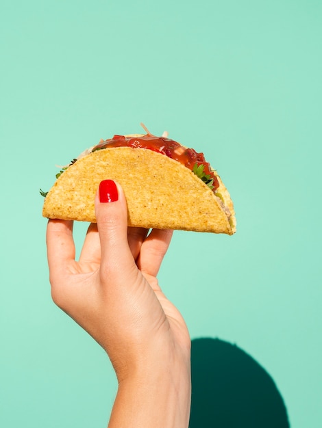 Close-up woman with taco and green background