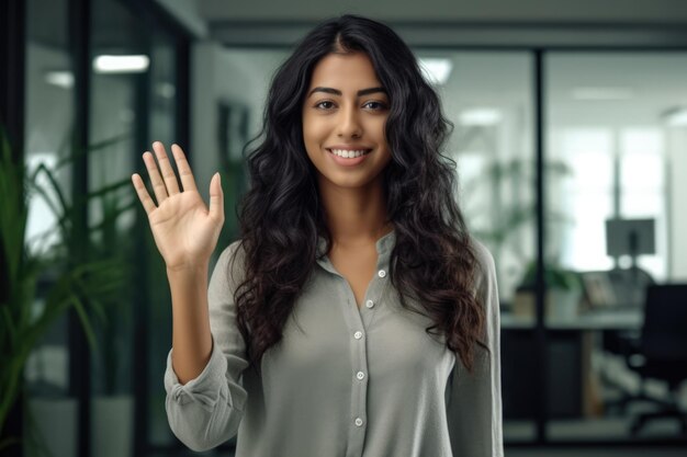 Close up of a woman at work smiling at her workplace and giving a high five to the camera