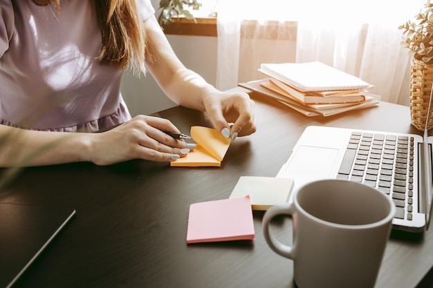 Close up of a woman writing something on the paper in office