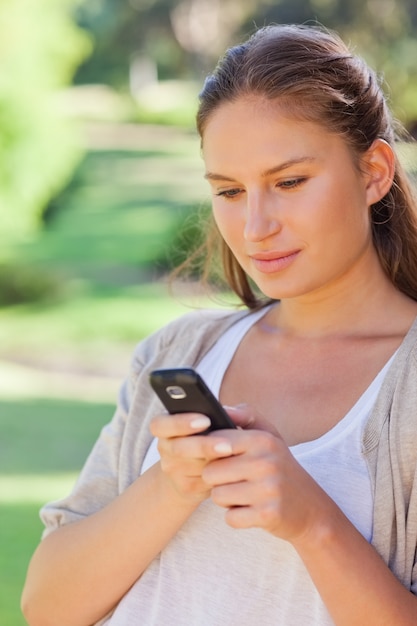 Close up of woman writing a text message in the park