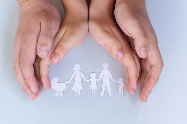 Close up of womans cupped hands showing paper man family