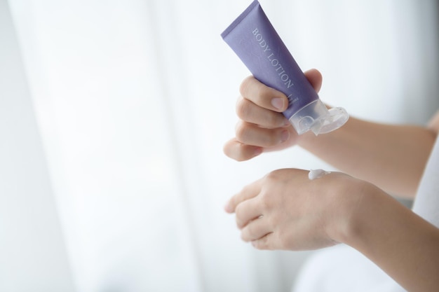 Close up of women applying body lotion cream on hand