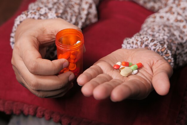 Close up of women hand taking pills.