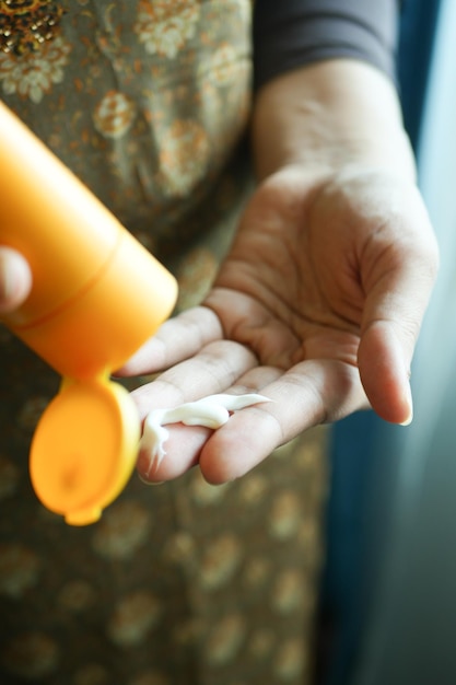 Close up of women hand using sunscreen cream