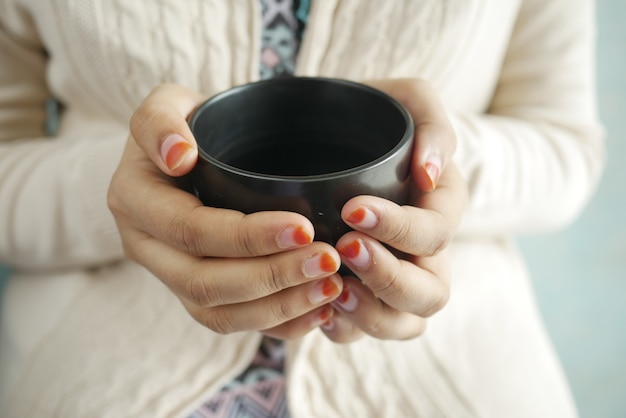 Close up of womens hand holding coffee mug