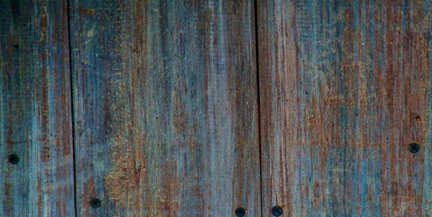 A close up of a wooden door with rusted metal on it