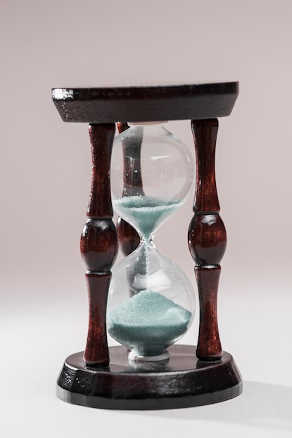 Close-up of a wooden hourglass on white background