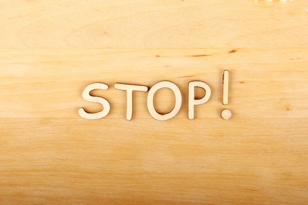 Close up wooden letters word STOP Background