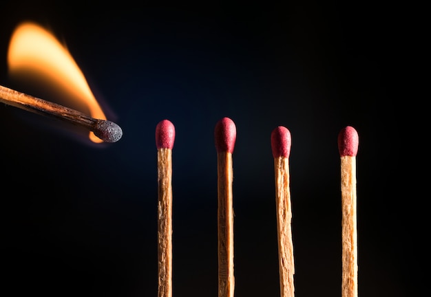 Close-up of wooden match lighting up. 