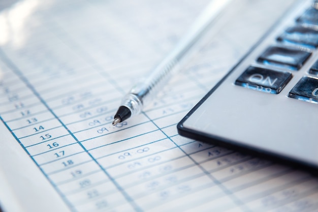 Close-up of work entry record, pen and calculator. Human resources concept.