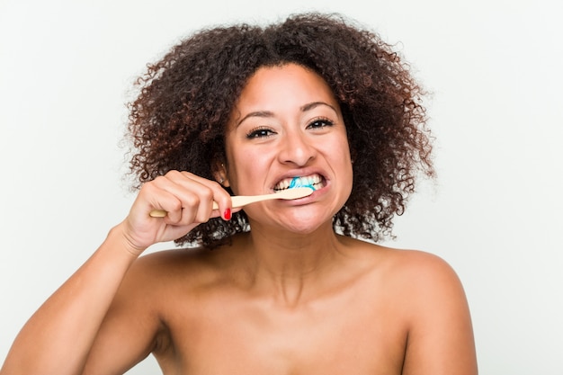 Close up of a young african american woman brushing her teeth with a toothbrush