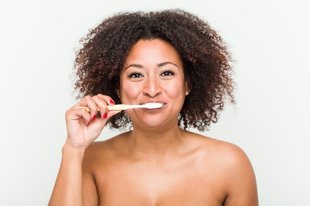 Close up of a young african american woman brushing her teeth with a toothbrush