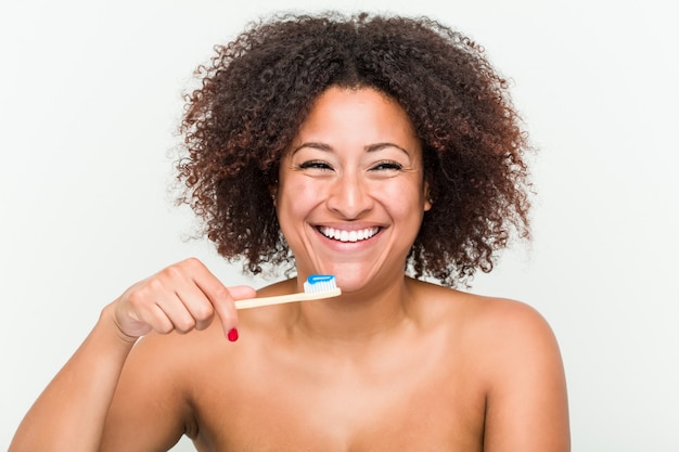 Close up of a young african american woman brushing her teeth with a toothbrush