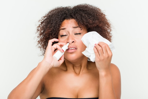 Close up of a young african american woman using a nasal spray