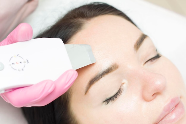 Close up of a young attractive woman getting ultrasonic facial skin cleansing treatment by professional cosmetologist beautician dermatology cosmetology skincare clean fresh rejuvenation wellness