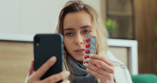 Close up young attractive woman patient talk to doctor on cellphone videocall conference medical app in telehealth telemedicine at home.