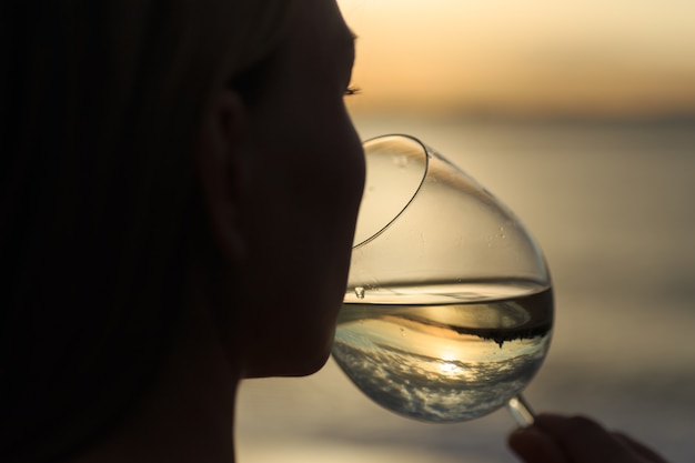 Close up of young beautiful woman drinking white wine