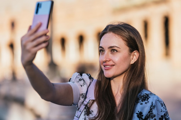 Close up of a young beautiful woman taking a selfie while sightseeing