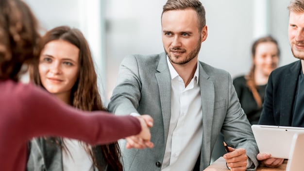 Close up. young businessman shaking hands with his business partner . concept of cooperation