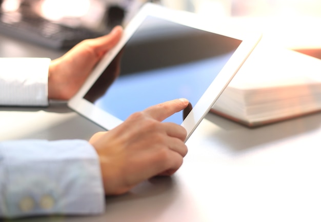 Close-up of young businesswoman hands working with touchpad.