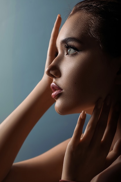 Close up of young caucasian woman with hand near her face,