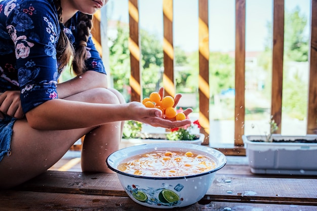 Close up of a young girl cleaning fruits with water