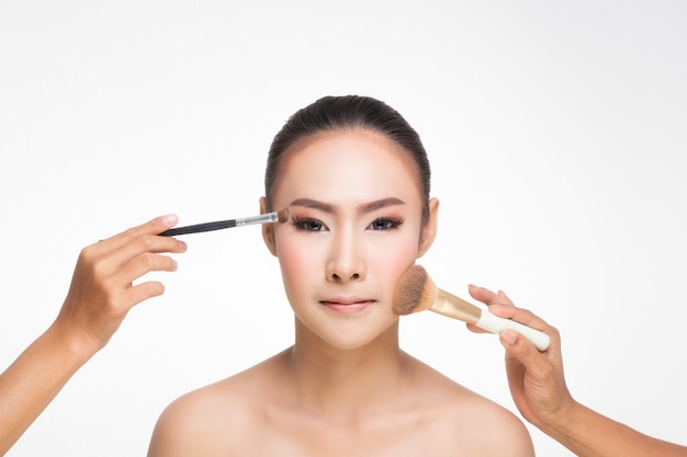 Close up of young girl face and makeup brush.