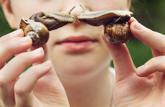 Close up on young girl holding snails in hands