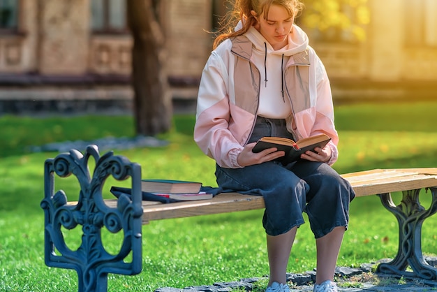 Close up on a young girl reading a book in a park