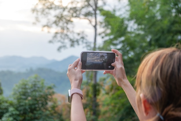 Close up of a young girl taking pictures of the mountains