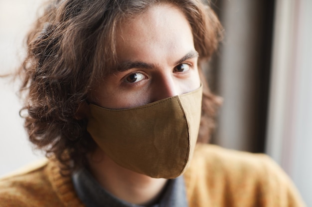 Close-up of young handsome man in mask looking at camera