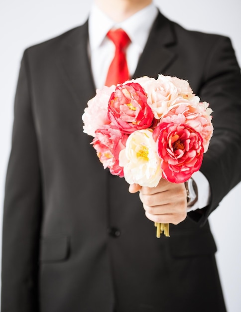 close up of young man giving bouquet of flowers.