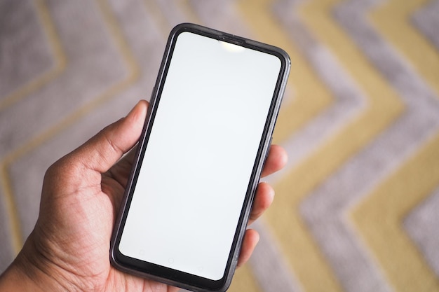 Close up of young man hand using smart phone with green screen