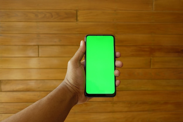 Close up of young man hand using smart phone with green screen